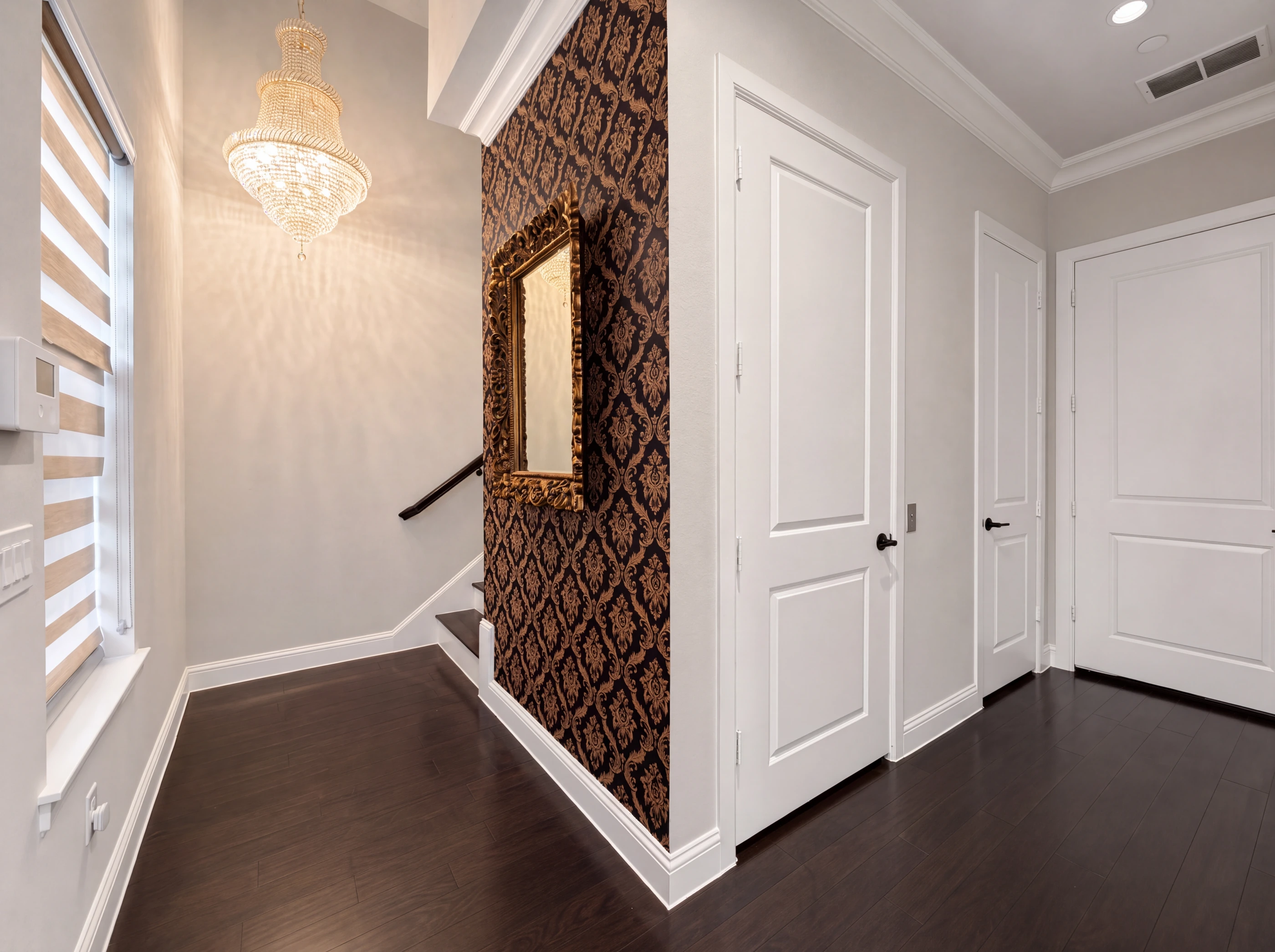 Entry at Brownstones #804 with crystal chandelier and damask accent wall